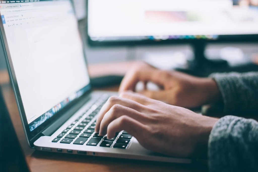An image of a person typing on a laptop
