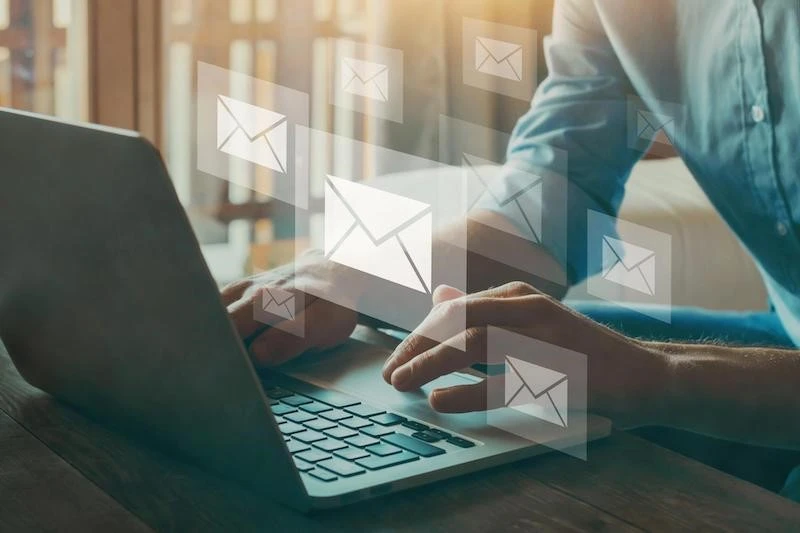 Working in a laptop with email icons