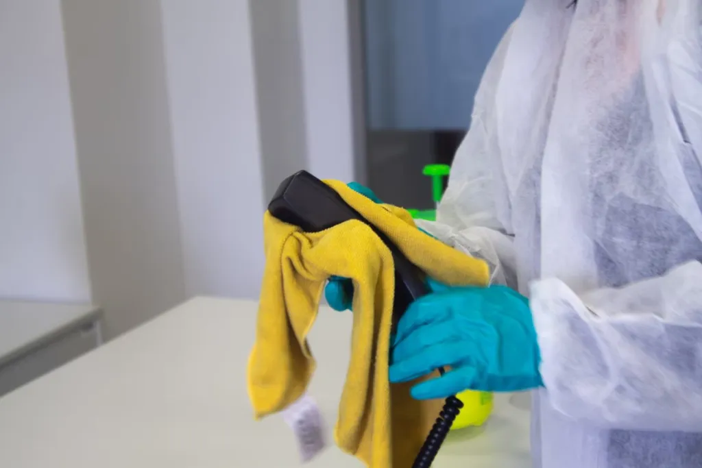 A man wearing gloves holding a cleaning rag