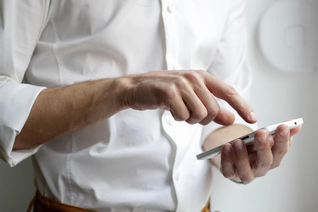 A man pointing one finger on his phone