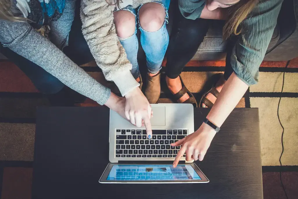 People pointing in laptop screen